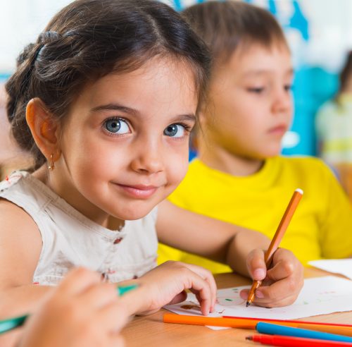 Group of cute little prescool kids drawing with colorful pencils